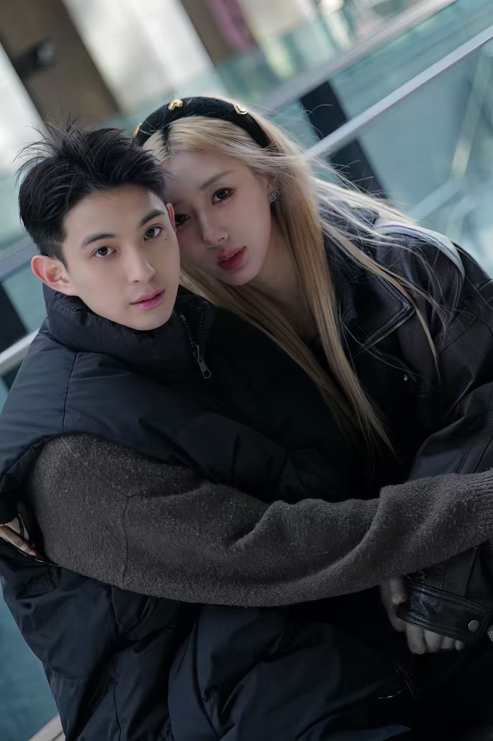 A close portrait of a couple embracing beside glass railings