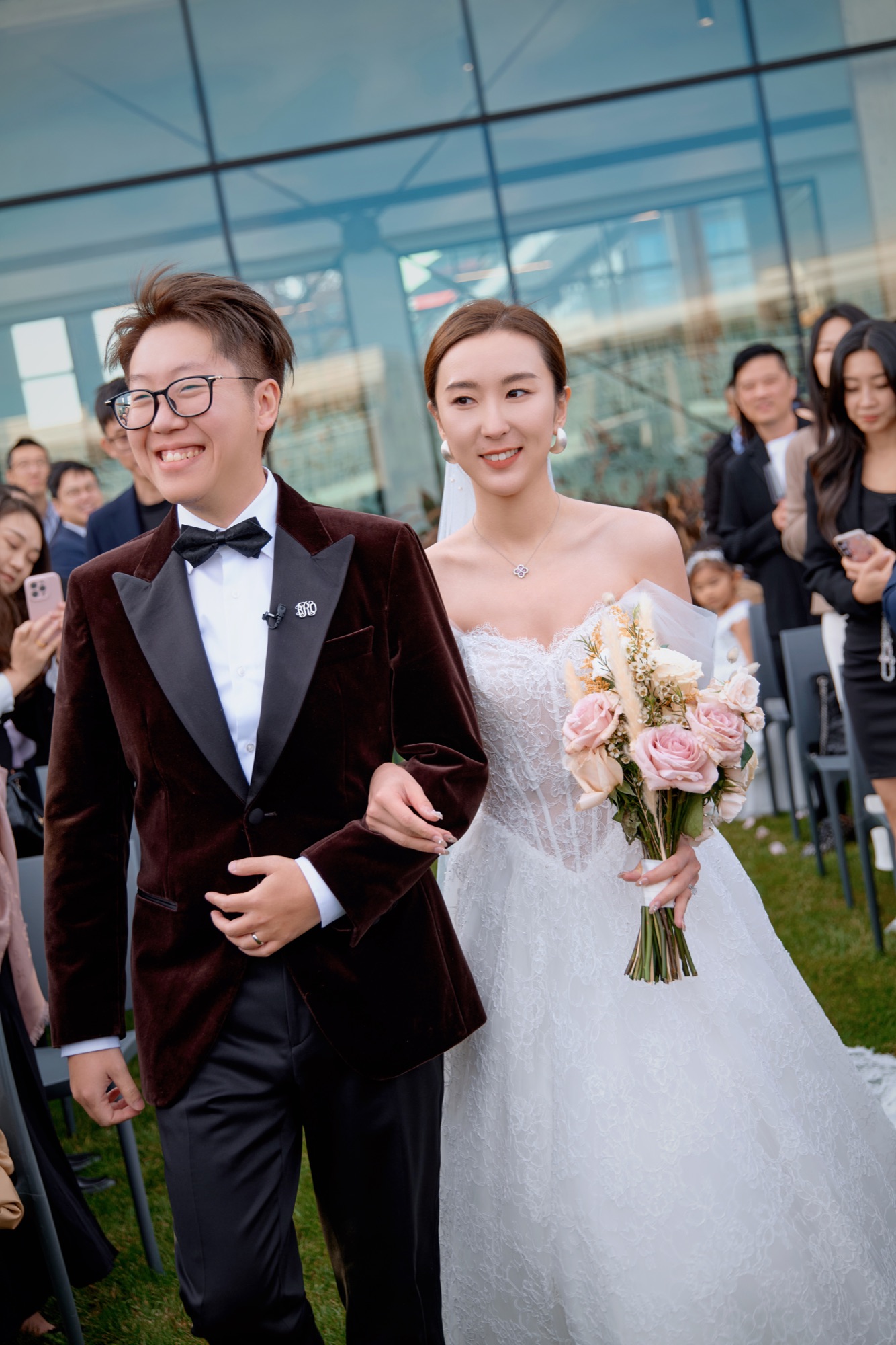 Newlyweds walking among smiling guests