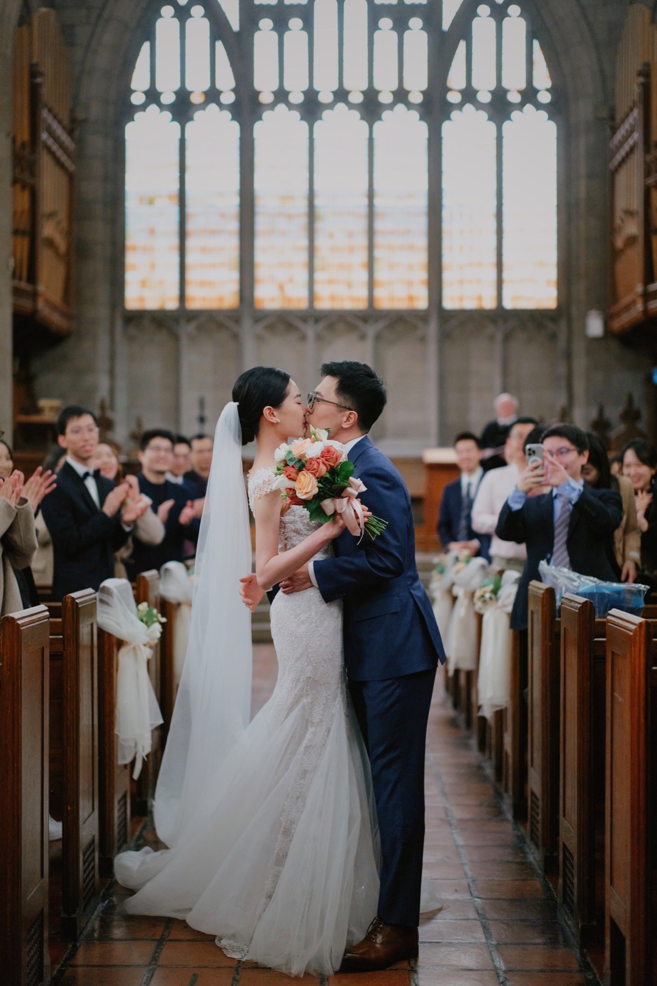A wedding kiss surrounded by guests